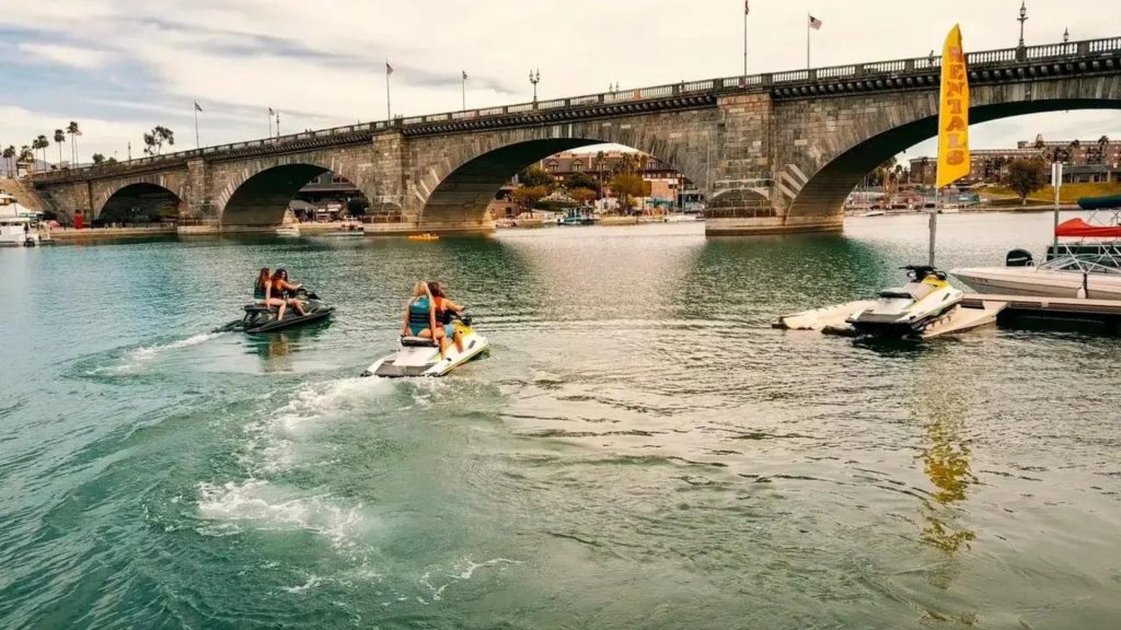 Jet Skis Near A Stone Bridge On A Calm Waterway