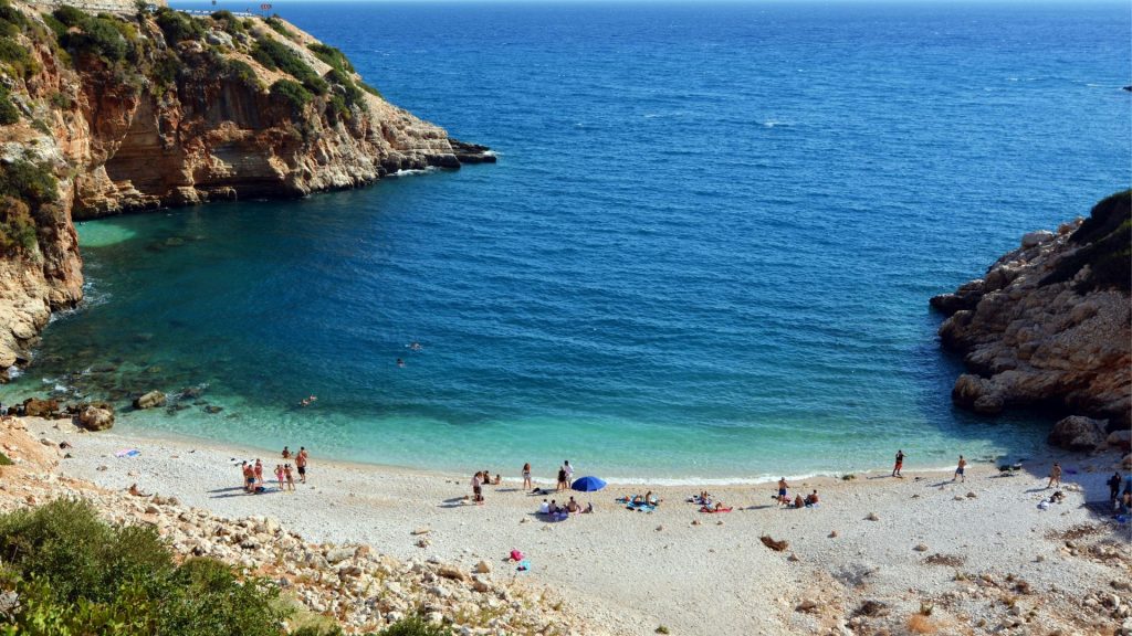 People Relaxing On The Small Beach Cove
